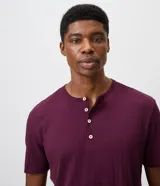 Remera masculina negra de manga corta, con cuello redondo y abertura frontal tipo Henley con botones claros. Presenta un diseño de textura acanalada vertical y corte regular.