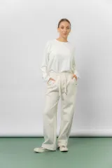 Pantalón deportivo de corte wide leg con caída relajada. Presenta cintura elastizada con cordón ajustable, bolsillos laterales y un interior frizado para mayor abrigo.