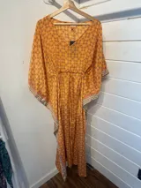 Kaftan largo con estampado floral en tonos turquesa y fucsia, con detalles de guarda pampa en los bordes.