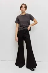 Pantalón negro de corte flare, tiro alto y diseño ajustado en la parte superior con piernas acampanadas.