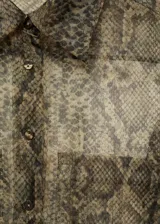 Camisa de organza semitransparente con estampado de serpiente en tonos marrones y verdes. Tiene corte recto, cuello camisero, dos bolsillos de parche en el frente y cierre de botones.