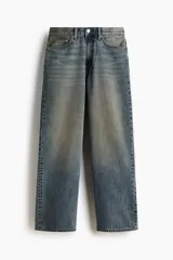 Jean de corte baggy en denim de algodón rígido, color azul con efecto deslavado y acabado vintage. Diseño de cinco bolsillos, tiro bajo y piernas amplias redondeadas.
