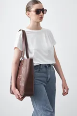 Remera básica de manga corta en color blanco, con cuello redondo y detalle de pliegues sutiles en los hombros.