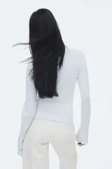 Top ajustado de punto acanalado suave, color celeste, con cuello alto y mangas largas acampanadas.