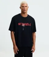 Remera negra de algodón con corte boxy, cuello redondo y mangas cortas. Presenta un estampado frontal en rojo con el texto "MY CHEMICAL ROMANCE" y una araña colgando de una telaraña.