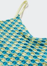 Vestido corto entallado de tejido elástico con textura, estampado geométrico en tonos turquesa y amarillo, escote en pico y tirantes finos.