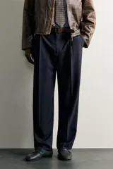 Pantalón relaxed fit azul marino confeccionado en tejido con lana, con bolsillos frontales, bolsillos traseros de doble vivo y pliegues en la parte delantera.