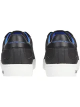 Zapatillas urbanas Calvin Klein con diseño de corte bajo. Presentan una combinación de materiales en la capellada, incluyendo paneles de nailon, cuero y ante en color negro. Destacan por su suela de goma blanca con el logo de la marca estampado en el lateral, forro interior en color azul vibrante y cierre mediante cordones.
