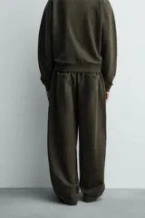 Pantalón jogger de algodón color verde oscuro, con efecto lavado, corte balloon fit y cintura elástica. Presenta bolsillos delanteros y bolsillos traseros de plastrón.