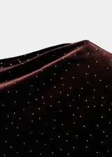 Vestido corto de terciopelo con brillos, diseño entallado, cuello asimétrico y manga larga.