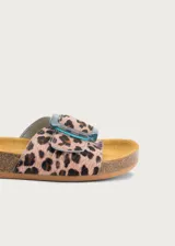 Sandalia plana con plantilla ergonómica y suela de corcho. Capellada de cuero con estampado animal print tipo leopardo y tira ancha ajustable con hebilla grande de resina translúcida en tono azulado.