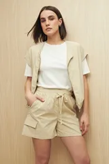 Short color beige, estilo cargo, con cintura elastizada, cordón ajustable y bolsillos laterales con tapa.