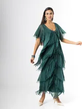 Vestido largo de seda italiana color verde oscuro, con capas escalonadas con flecos, escote en V con detalle de paillettes y mangas cortas fluidas.