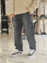 Pantalón cargo de jean gris con efecto acid wash, corte holgado, bolsillos laterales en las piernas y costuras reforzadas.