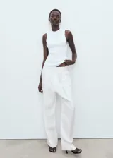 Top de punto canalé color blanco, de diseño entallado con cuello redondo y tirantes anchos sin mangas.