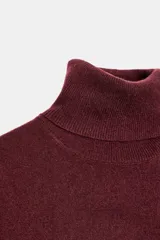Jersey de corte oversize confeccionado en lana 100%, con cuello subido y manga larga.