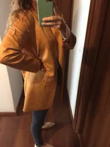 Blazer color camel, de corte recto y largo a la cadera, confeccionado en tela símil gamuza.