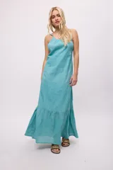 Vestido largo color celeste, de tirantes finos y espalda descubierta. Presenta volados en el ruedo y escote fruncido.