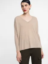 Sweater de punto fino color beige, con escote en V y mangas largas de corte relajado.