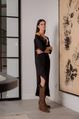 Vestido corto negro de tejido de punto con cuello en V, mangas 3/4, flecos en el ruedo y apliques de cuero en escote y hombros.