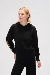 Sweater con capucha de tejido de punto color crema, con diseño holgado y franjas laterales con estampado animal print en las mangas.