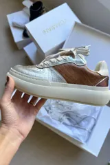 Championes de plataforma con diseño combinado en cuero texturizado con efecto reptil en color plata y marrón. Presenta suela de goma blanca, cordones plateados y detalles metalizados en el talón.