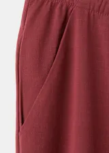 Pantalón largo de corte recto y holgado color bordó, con cintura ajustable mediante elástico y lazo, y bolsillos laterales.