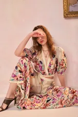 Falda larga amplia de viscosa con estampado floral multicolor en tonos rosados, morados y marrones sobre base beige.