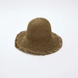 Sombrero tipo campana de paja color marrón caqui, con ala ancha y flecos en los bordes.