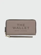 Billetera Marc Jacobs The Continental Wallet de cuero negro, con cierre perimetral de cremallera metálica dorada y tirador de cuero. Interior con múltiples ranuras para tarjetas, compartimentos para billetes y monedero con cierre.