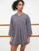 Remera deportiva oversize gris de manga corta, con cuello en V y confeccionada en tejido dry fit.