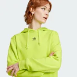 Hoodie Adidas Adicolor Essentials Regular color verde lima, con capucha ajustable con cordón, bolsillo tipo canguro y el logo del trifolio bordado en el pecho.