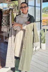 Trench reversible de corte largo, con un lado en color tostado liso y el otro lado con estampado de cuadros. Presenta cuello solapa, cierre frontal de botones, bolsillos laterales y puños con detalle de estampado a cuadros.