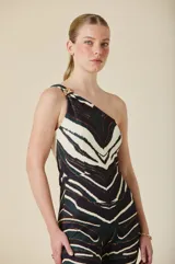 Mono de un solo hombro con estampa animal print en tonos tierra, oliva y negro. Confeccionado en jersey de poliéster y elastano, presenta un corte ajustado al cuerpo con pierna levemente acampanada desde la rodilla y detalle de hebilla dorada en el hombro.