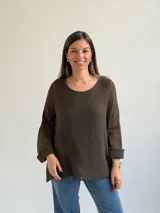 Sweater de punto abierto color marrón oscuro, de corte holgado, mangas largas y escote redondo.