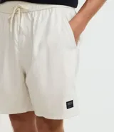 Bermuda masculina color verde con cintura elastizada ajustable con lazo, bolsillos laterales y traseros, y etiqueta de goma en el ruedo. Confeccionada en poliéster.