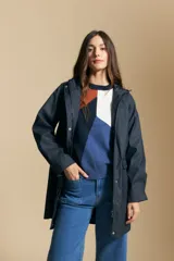 Pilot de largo medio color azul marino, con capucha integrada, cierre frontal oculto y bolsillos aplicados con tapa. Presenta una silueta recta y diseño funcional.