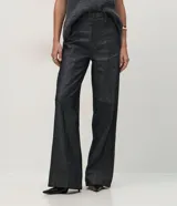 Pantalón wide leg de tiro alto confeccionado en denim de algodón. Presenta una pretina tipo sastrería con presillas, cierre frontal con botón y cremallera, bolsillos funcionales y nervaduras frontales que definen la silueta.