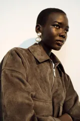 Aros colgantes de diseño circular doble, con piedras grises engarzadas en marcos dorados y bordes decorados con pequeños cristales oscuros.