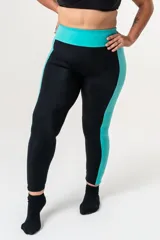 Calza deportiva de tiro alto con cintura elástica reforzada. Presenta un diseño bicolor que combina paneles laterales y faja con estampado animal print en tonos coral y turquesa sobre una base negra.