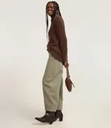 Suéter de punto color crema con cuello redondo y mangas largas ajustadas. Modelo slim alargado con efecto de pelitos.