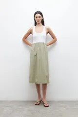 Vestido midi con parte superior blanca tipo musculosa y falda verde con rayas verticales blancas.