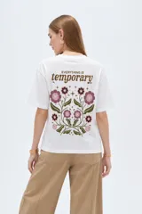 Remera blanca de manga corta, cuello redondo a la base y diseño holgado, confeccionada en algodón.