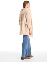 Cardigan de textura tipo sherpa o corderito, color beige, con diseño abierto sin botones, mangas largas con puños elásticos y capucha integrada. Presenta bolsillos laterales diagonales y un corte holgado.