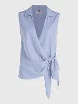 Blusa sin mangas con cuello camisero, diseño cruzado con lazo en la cintura y estampado a rayas verticales azules y blancas.