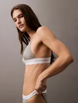 Corpiño triangular sin forro de Calvin Klein, confeccionado en tejido acanalado de mezcla de algodón y modal. Presenta una banda elástica inferior con el logo de la marca, tirantes ajustables y cierre de corchete en la espalda.