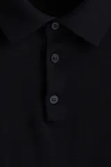 Remera polo de manga larga confeccionada en tejido de punto de lana merino, con cuello clásico, tapeta de botones frontal y terminaciones acanaladas en puños y cintura.