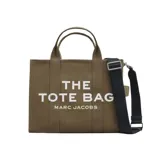 Bolso tote de lona color beige con estampado frontal en blanco con el nombre del modelo y la marca. Cuenta con doble asa superior, correa de hombro ajustable y extraíble en color negro, y cierre superior con cremallera.