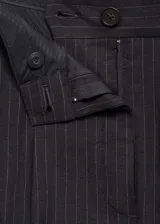 Pantalón de vestir de corte recto y tiro medio, confeccionado en tejido mezcla de algodón y lino con estampado de rayas verticales. Cuenta con cierre delantero de cremallera y botón, trabillas para cinturón y dos bolsillos laterales.