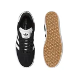 Championes adidas Gazelle ADV de corte bajo, confeccionados en gamuza negra con las icónicas tres tiras laterales en blanco. Presentan suela de goma blanca, lengüeta blanca con logo y detalle de marca Gazelle en dorado en el lateral.